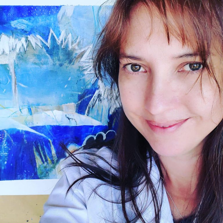 Kathryn Gruber Abstract Artist - portrait in front of a blue mixed media abstract painting.