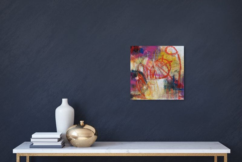 Insitu image of "Bold", a highly expressive abstract artwork by Kathryn Gruber, set against a black wall with a shelf underneath and two small vases, one white and the other gold, set amonst a few books to the left of the image.