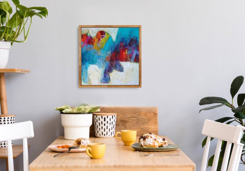 An image of "Taking Flight", a mixed media abstract painting by Kathryn Gruber, set in a home environment above a dining table.